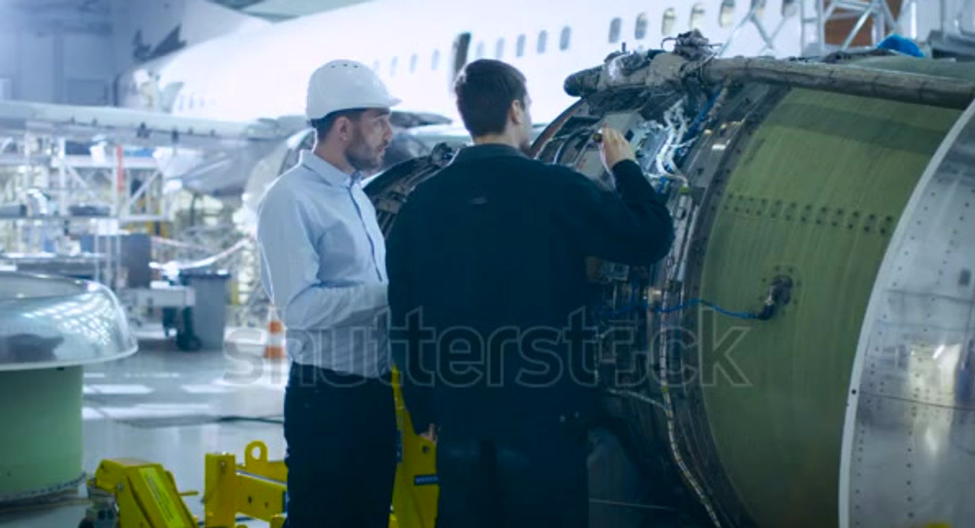 stock-footage-aircraft-maintenance-engineer-and-mechanic-inspecting-and-working-on-airplane-jet-engine-in-hangar